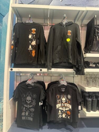 Black Howl-O-Scream zip hoodie, long-sleeve top, and T-shirts with skulls, bats, pumpkins, and other Halloween symbols.