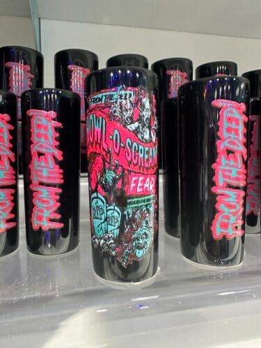 Black Howl-O-Scream souvenir glasses with pink and teal monster artwork and From the Deep lettering.